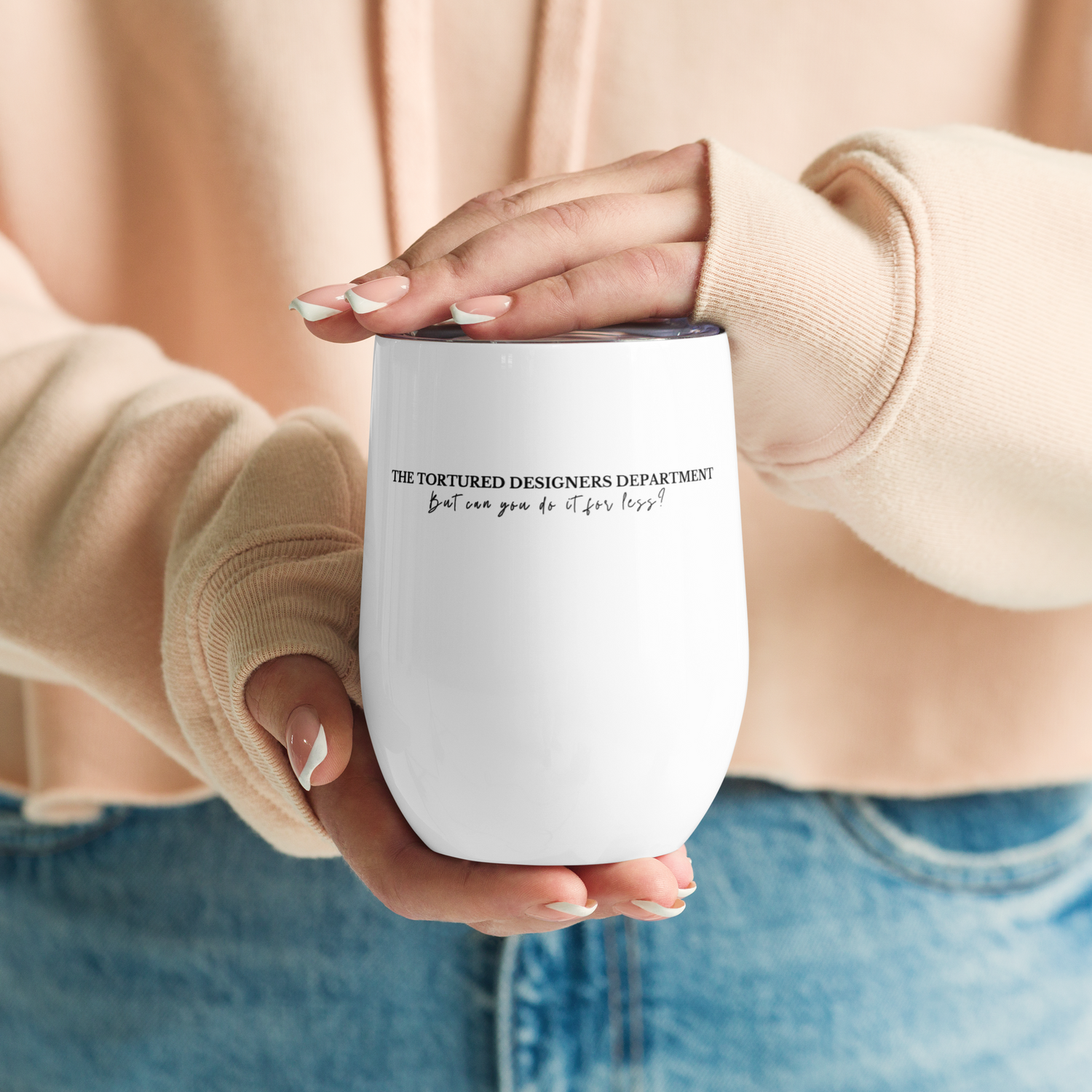 Woman holding white insulated wine tumbler with clear lid in black text says The Tortured Designers Department...but can you do it for less?